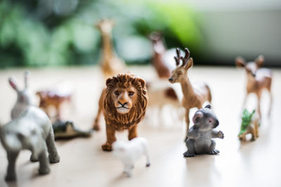 Tisch voller verschiedener Tierfiguren im Vordergrund ein Löwe